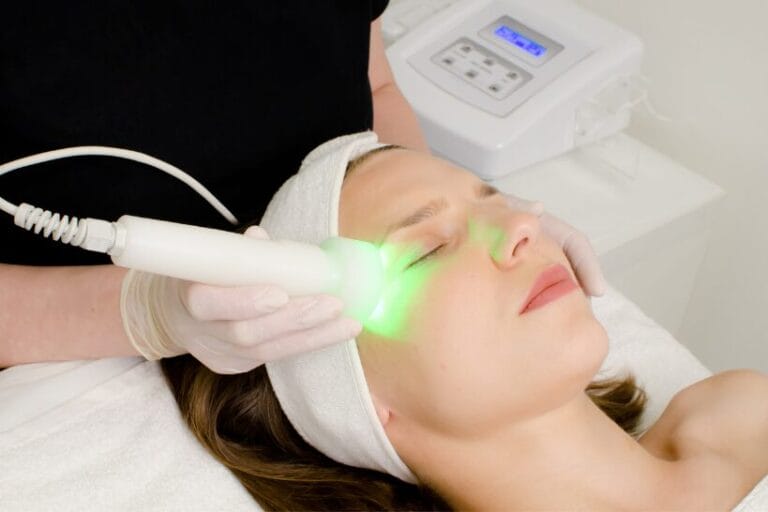 Provider performs an intense pulsed light (IPL) treatment around a woman’s eyes using a handheld device while she lies on a treatment bed.